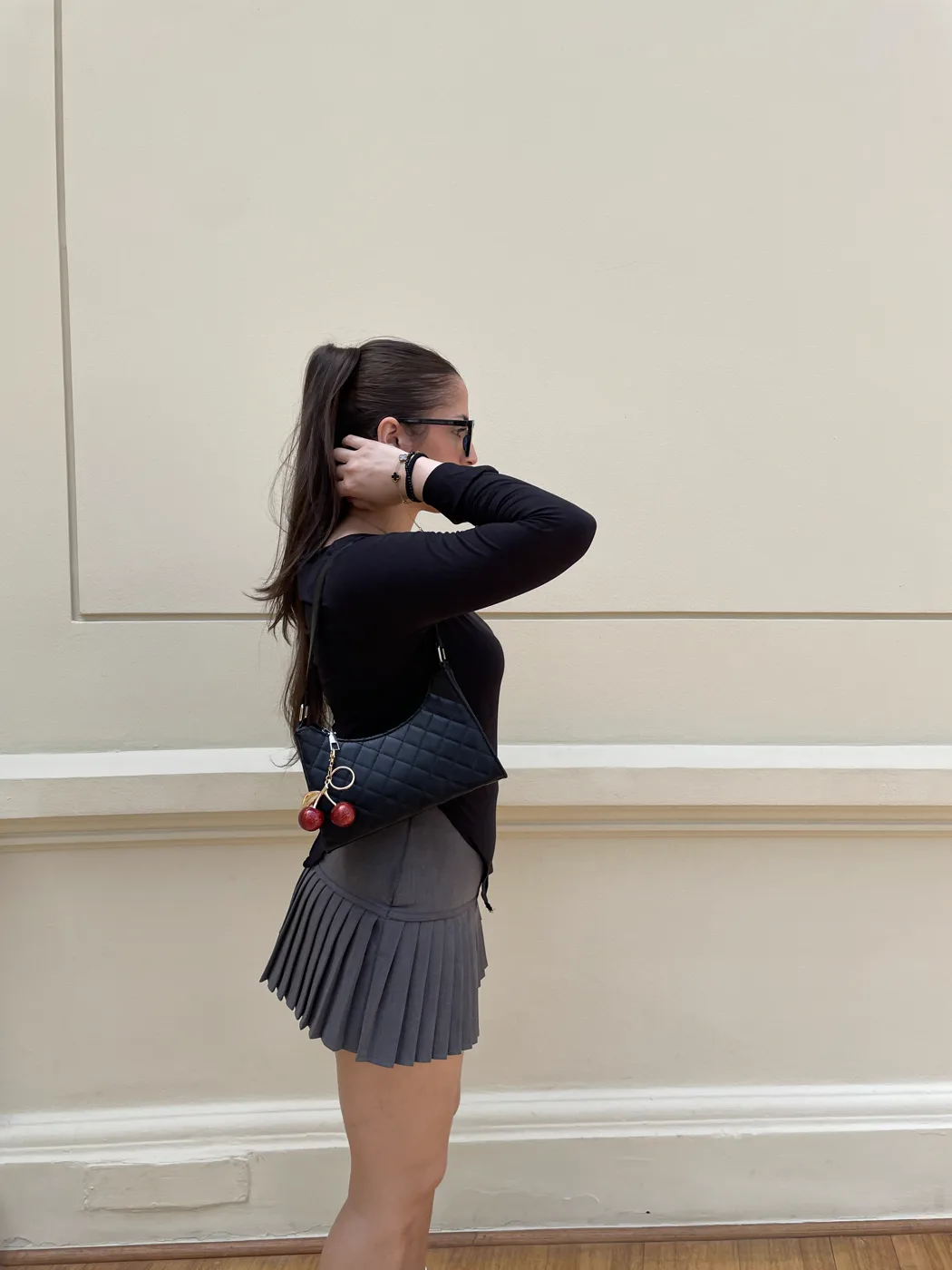 Susana de perfil con falda plisada gris